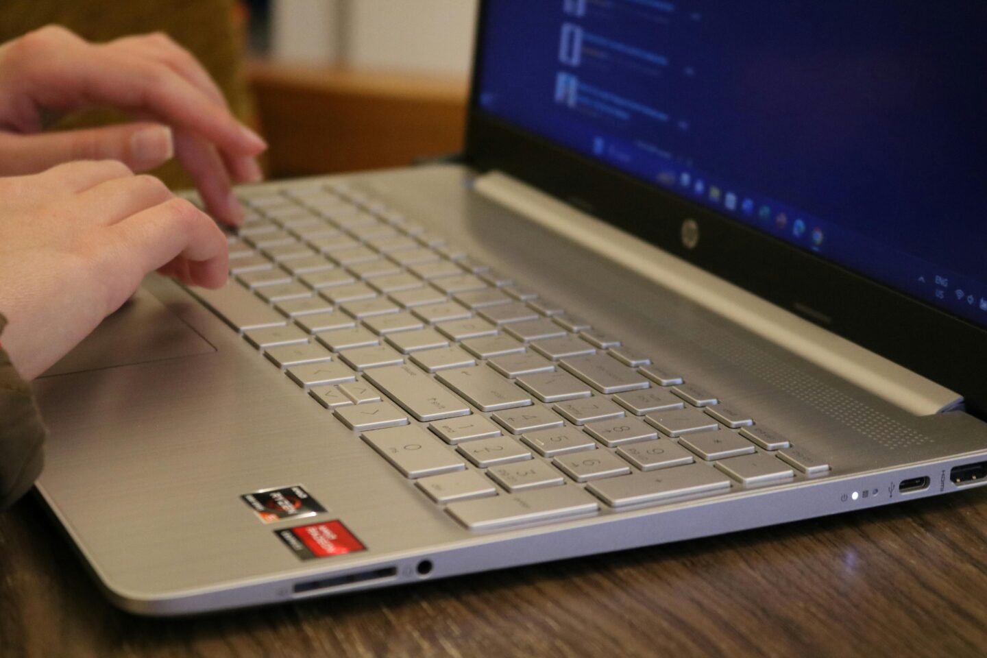 A close-up of fingers typing on a sleek HP laptop, symbolizing how HP provides seamless computing experiences for productivity and innovation.
