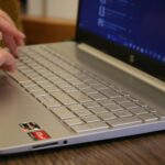 A close-up of fingers typing on a sleek HP laptop, symbolizing how HP provides seamless computing experiences for productivity and innovation.