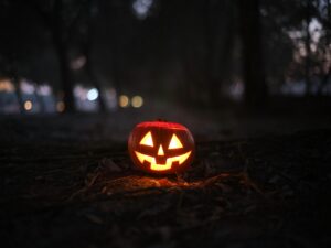A glowing jack-o'-lantern in a dark forest, representing the wide selection of Halloween decorations and pumpkin lights you can find on AliExpress to enhance your spooky setup.