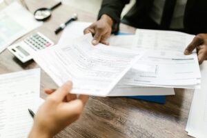 Two individuals reviewing paperwork, illustrating the ease and transparency of Avanti Travel Insurance's claims process, where submitting and managing claims is made simple and stress-free for travelers.