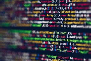 Blurred code on a monitor displaying vibrant lines of programming, representing the advanced web development tools and secure hosting services provided by Nazwa.