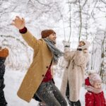 A cheerful family dressed in warm winter jackets enjoying a snowy day outdoors. Illustrates the comfort and style of Volcano’s insulated jackets, perfect for staying warm during winter activities.